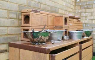 MPStNewington-1730 Bright children’s play kitchen with wooden blocks and metal bowls at Monkey Puzzle Day Nursery Stoke Newington.