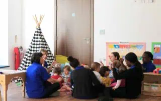 MPStNewington-1777 Colorful childcare classroom at Monkey Puzzle Day Nursery Stoke Newington with children and staff engaged in educational activities.