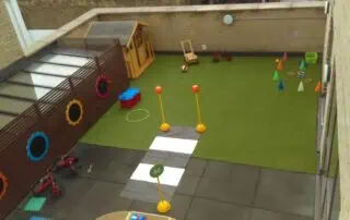 Picture1 Colorful outdoor play area at Monkey Puzzle Day Nursery Stoke Newington with sports equipment and toys designed for early childhood development.