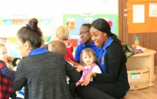Brightly lit classroom at Monkey Puzzle Day Nursery Stoke Newington with engaging children and caring staff, promoting early childhood development and early learning activities in a nurturing environment.