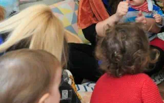 Monkey Puzzle Day Nursery Stoke Newington children engaging with a storytelling activity, featuring a caregiver wearing a lion-themed costume, creating a fun and educational environment for early childhood development.