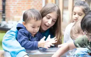Cute children engaging in outdoor sensory play at Monkey Puzzle Day Nursery Stoke Newington, fostering early childhood development and learning in a vibrant nursery environment.