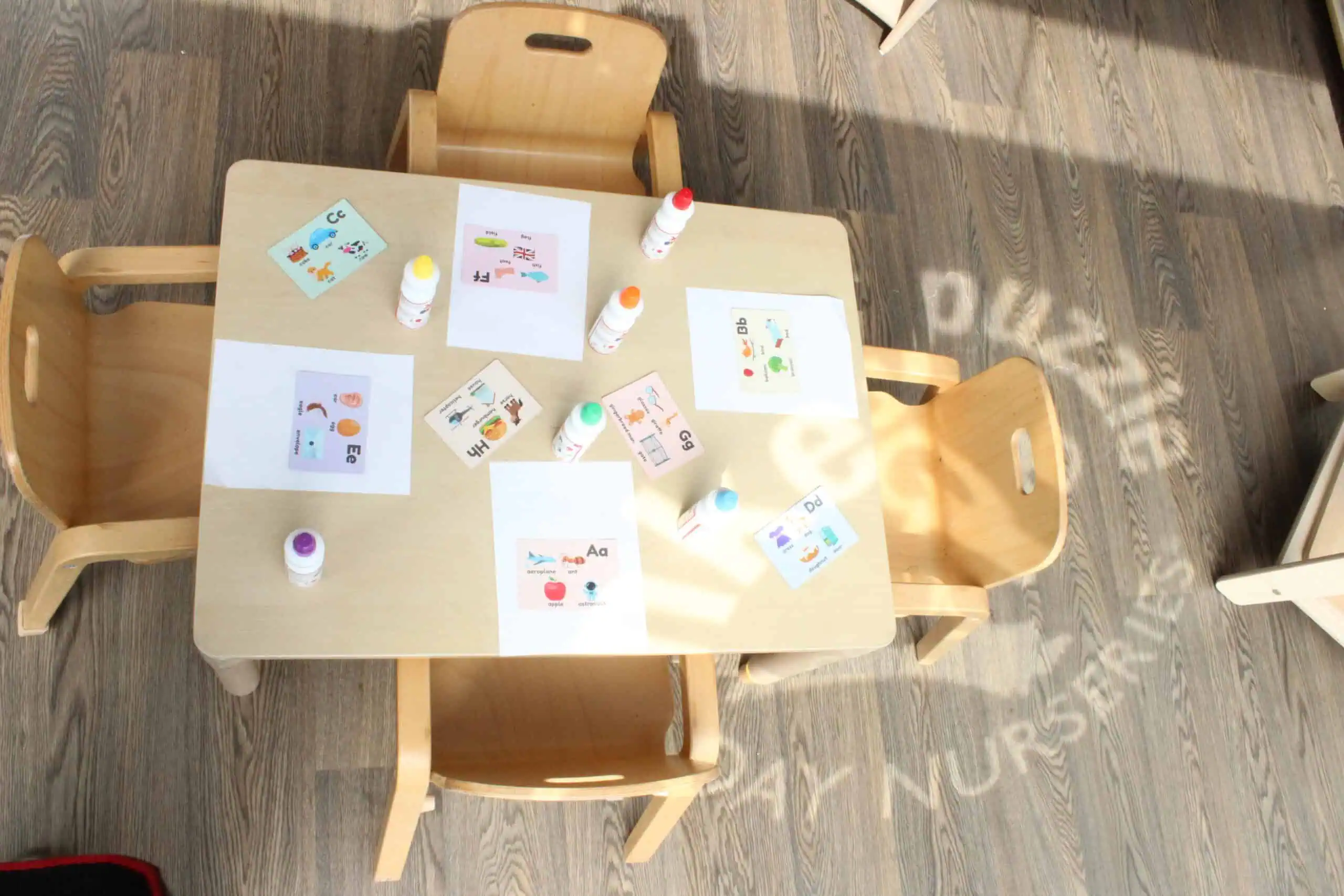 Colorful alphabet and language learning materials on a children's table at Monkey Puzzle Day Nursery Stoke Newington.