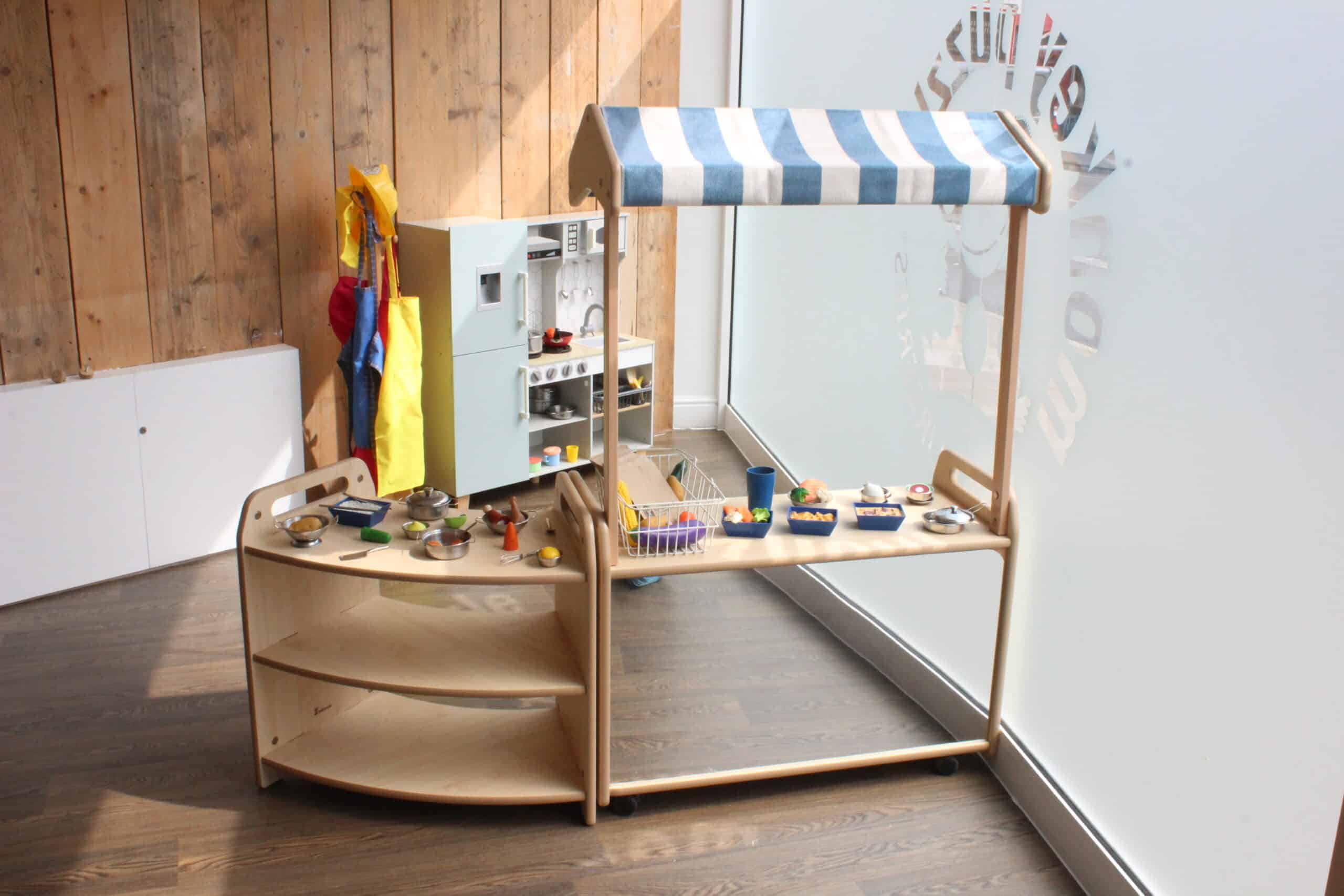Bright wooden toy kitchen and play food set in Monkey Puzzle Day Nursery Stoke Newington. Ideal for early childhood development and imaginative play in a safe nursery environment.
