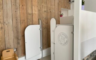 Preschool Monkey Puzzle Stoke Newington White nursery privacy screens with "Monkey Puzzle Day Nurseries" logo in a modern childcare setting.